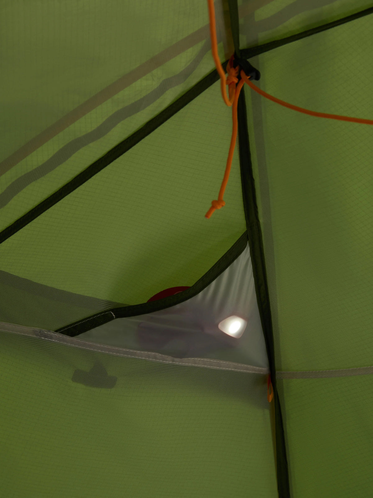Close-up of a green tent interior with a light source.